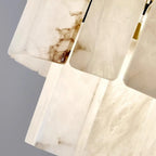 Lustre géométrique à plusieurs niveaux en pierre blanche et cristal, orné d'une chaînette.