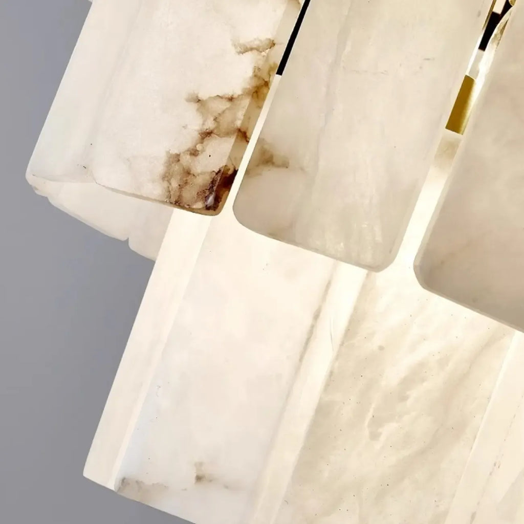 Lustre géométrique à plusieurs niveaux en pierre blanche et cristal, orné d'une chaînette.