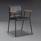 Chaise de salle à manger en cuir avec pieds en métal, accoudoirs et dossier.