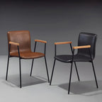 Chaise de salle à manger en cuir avec pieds en métal, accoudoirs et dossier.