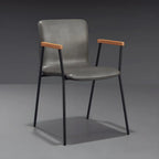 Chaise de salle à manger en cuir avec pieds en métal, accoudoirs et dossier.