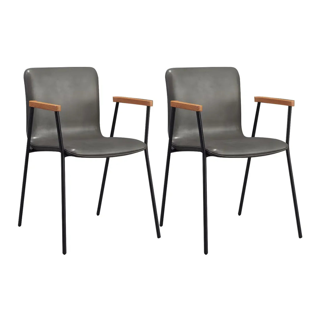 Chaise de salle à manger en cuir avec pieds en métal, accoudoirs et dossier.