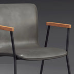 Chaise de salle à manger en cuir avec pieds en métal, accoudoirs et dossier.