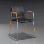 Chaise de salle à manger en cuir avec pieds en métal, accoudoirs et dossier.