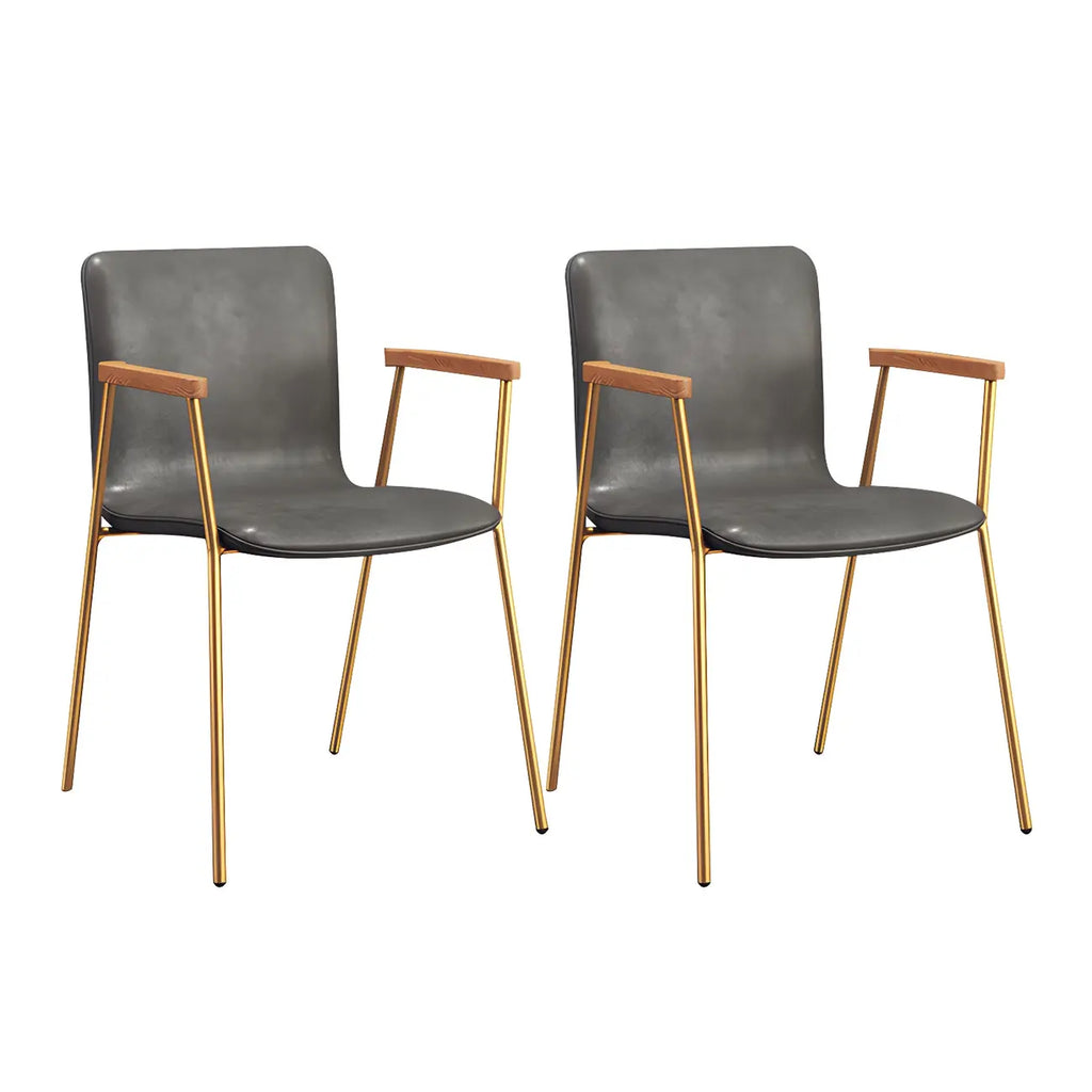 Chaise de salle à manger en cuir avec pieds en métal, accoudoirs et dossier.