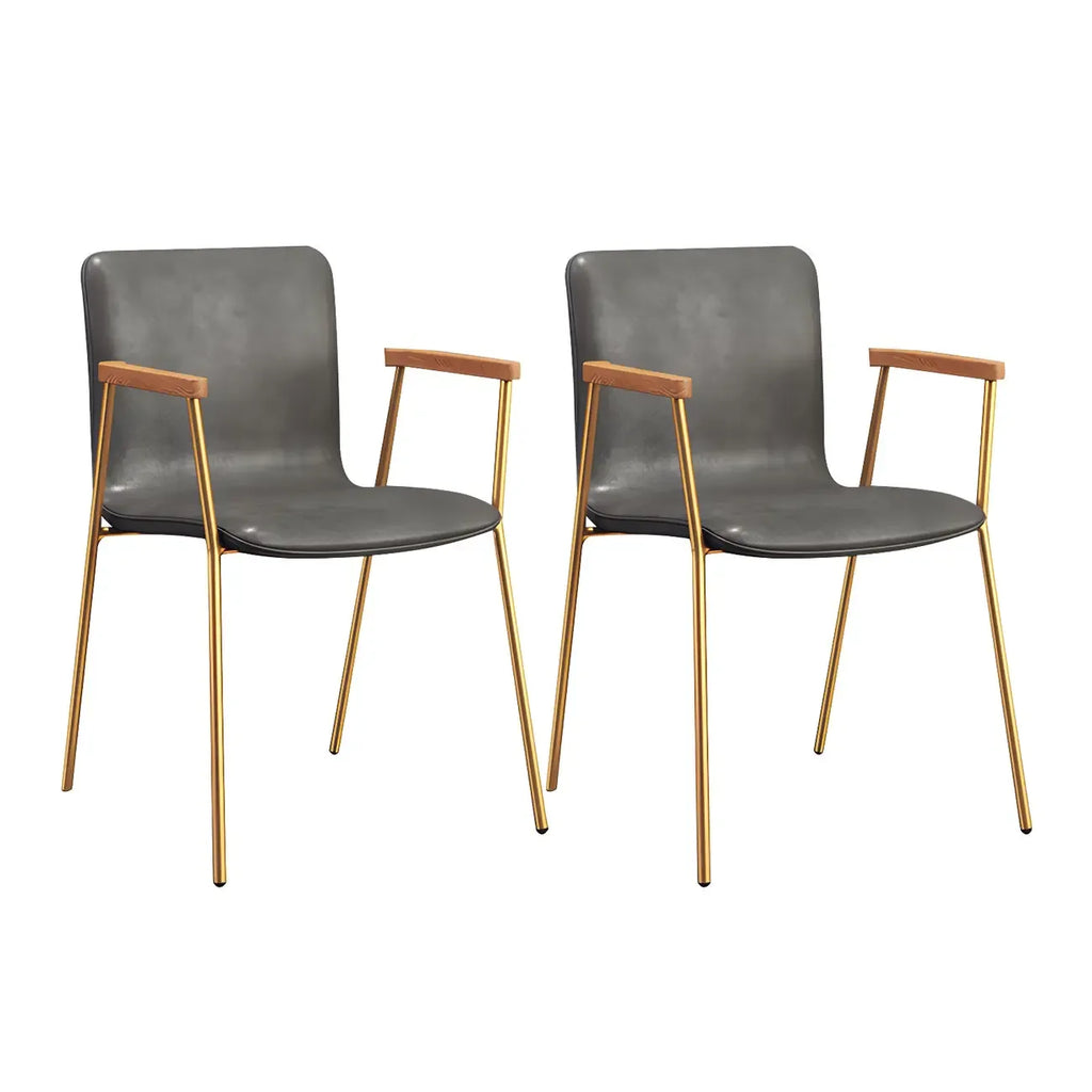 Chaise de salle à manger en cuir avec pieds en métal, accoudoirs et dossier.