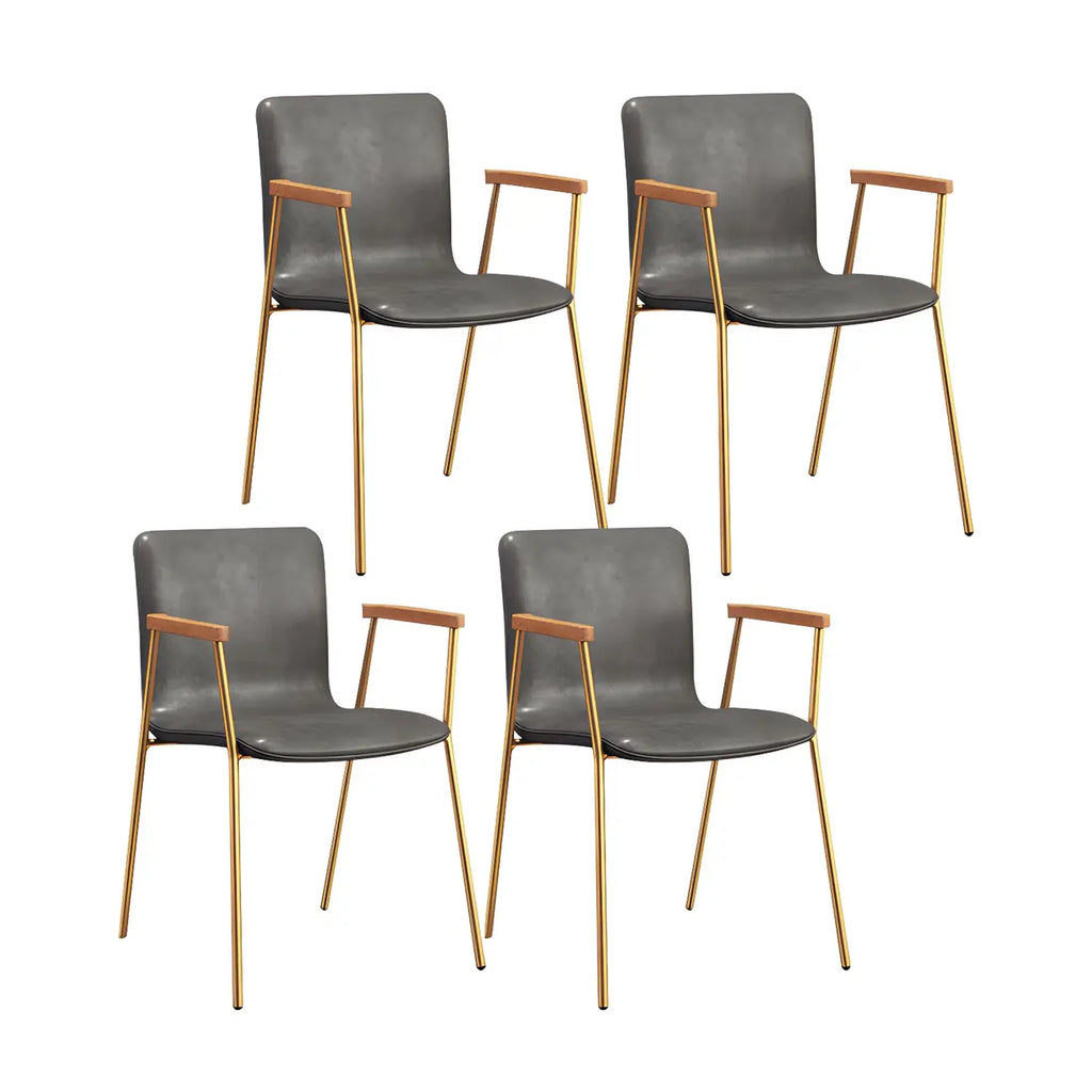 Chaise de salle à manger en cuir avec pieds en métal, accoudoirs et dossier.