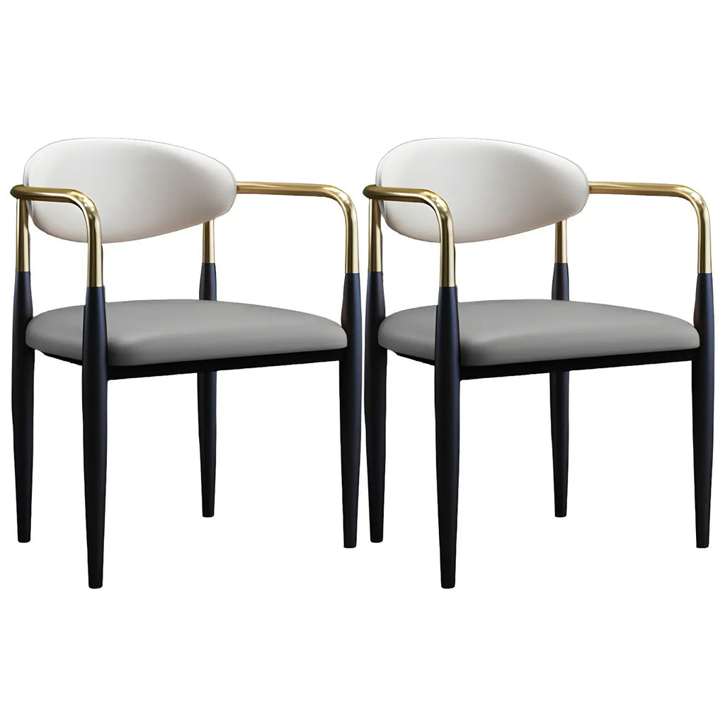 Chaise de salle à manger avec pieds en métal courbés et accoudoirs en similicuir.