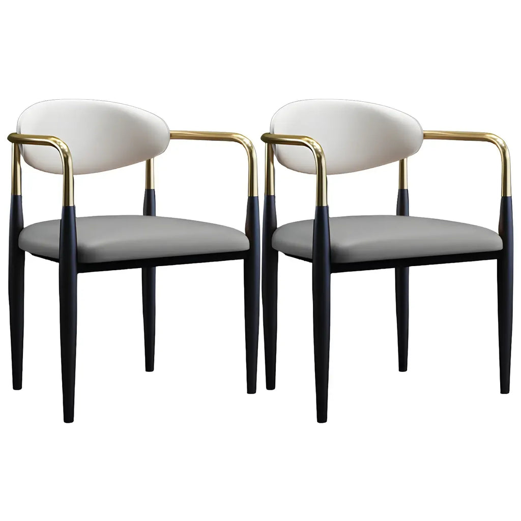 Chaise de salle à manger avec pieds en métal courbés et accoudoirs en similicuir.