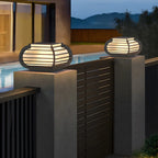 Poteau lumineux extérieur en métal en forme de tambour avec capuchon de protection pour grille.