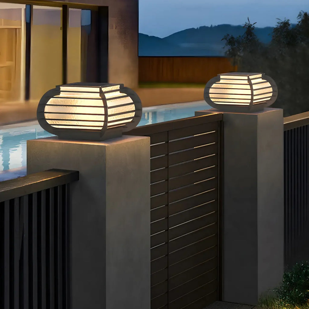 Poteau lumineux extérieur en métal en forme de tambour avec capuchon de protection pour grille.