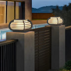 Poteau lumineux extérieur en métal en forme de tambour avec capuchon de protection pour grille.