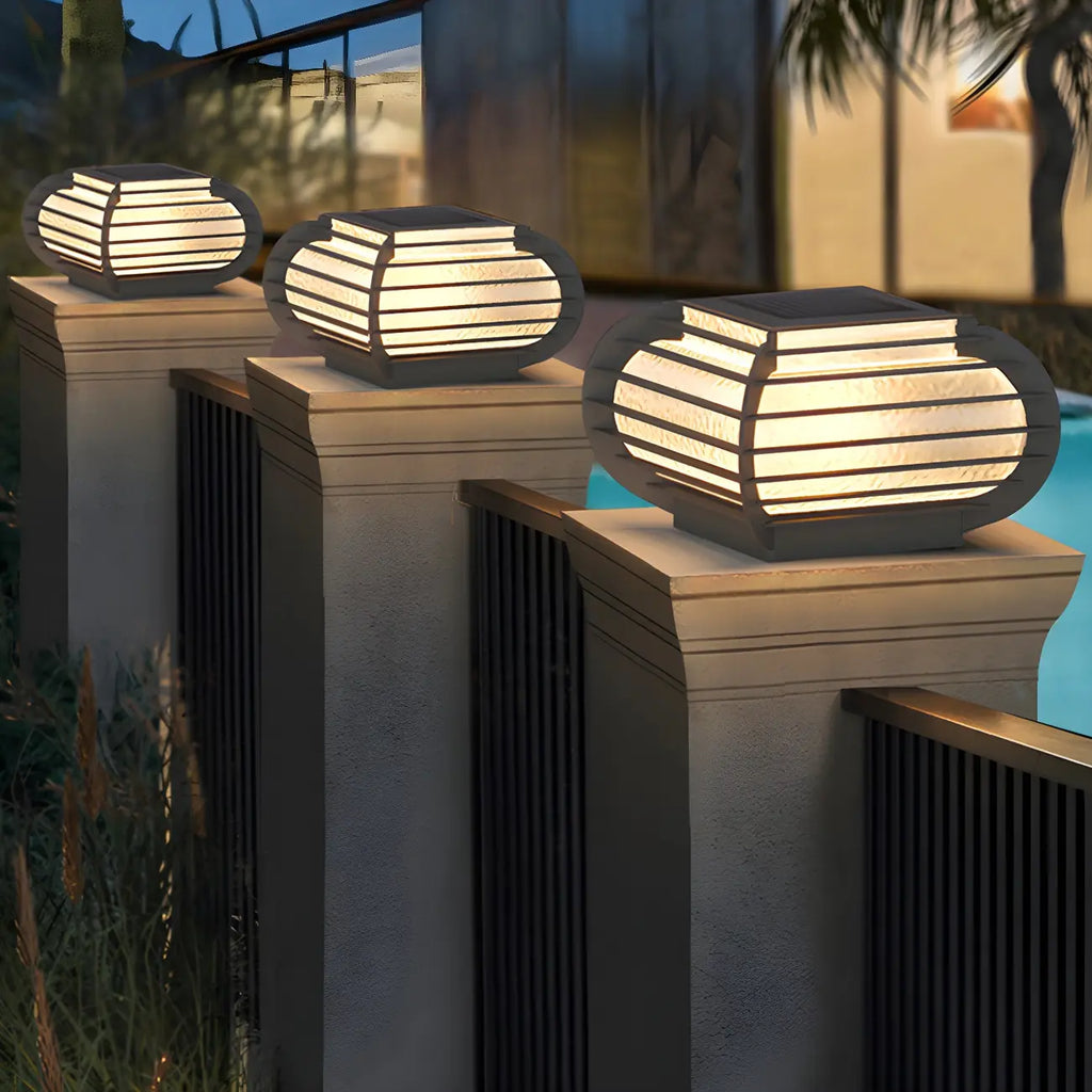 Poteau lumineux extérieur en métal en forme de tambour avec capuchon de protection pour grille.
