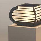 Poteau lumineux extérieur en métal en forme de tambour avec capuchon de protection pour grille.