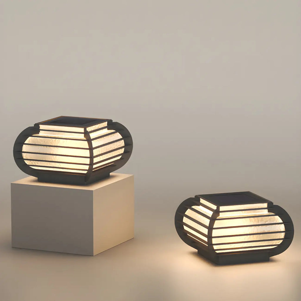 Poteau lumineux extérieur en métal en forme de tambour avec capuchon de protection pour grille.