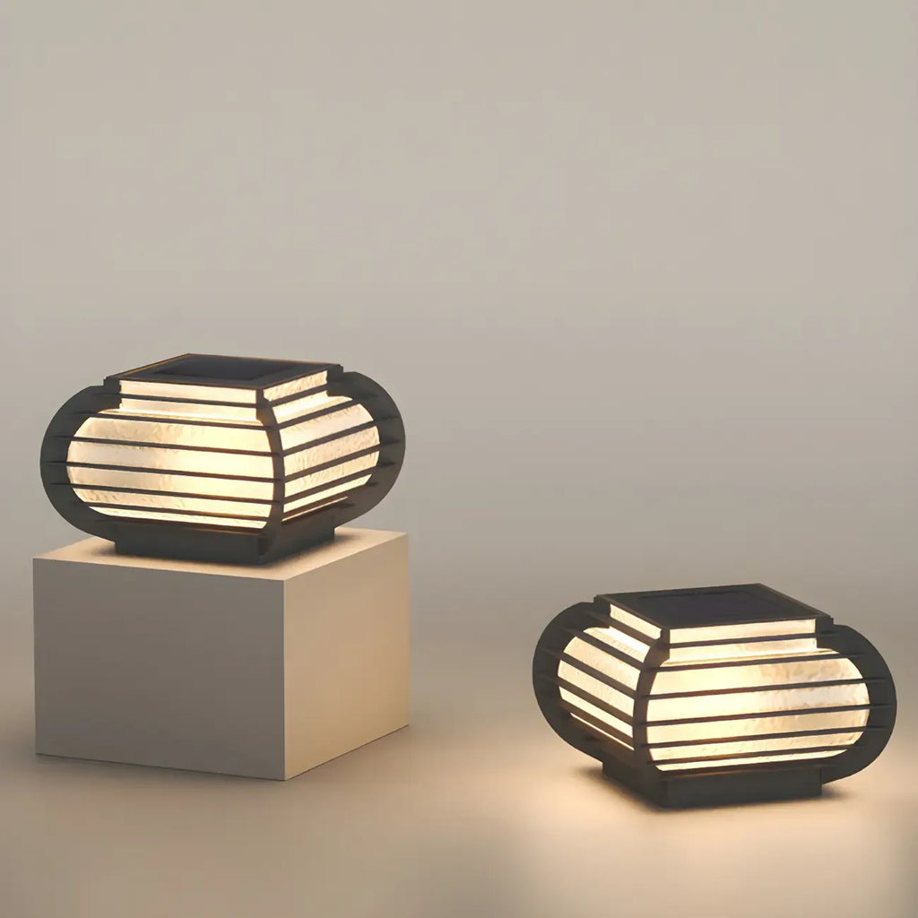 Poteau lumineux extérieur en métal en forme de tambour avec capuchon de protection pour grille.