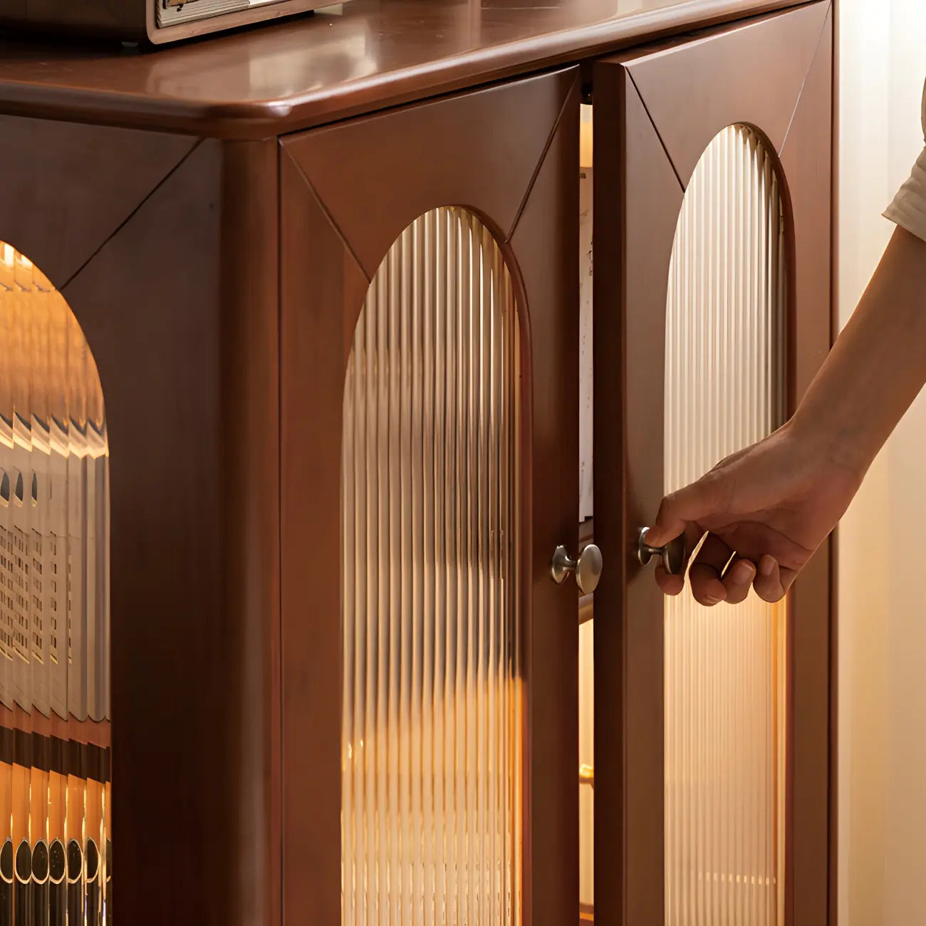 Petit vaisselier en bois brun avec porte vitrée et éclairage intégré.