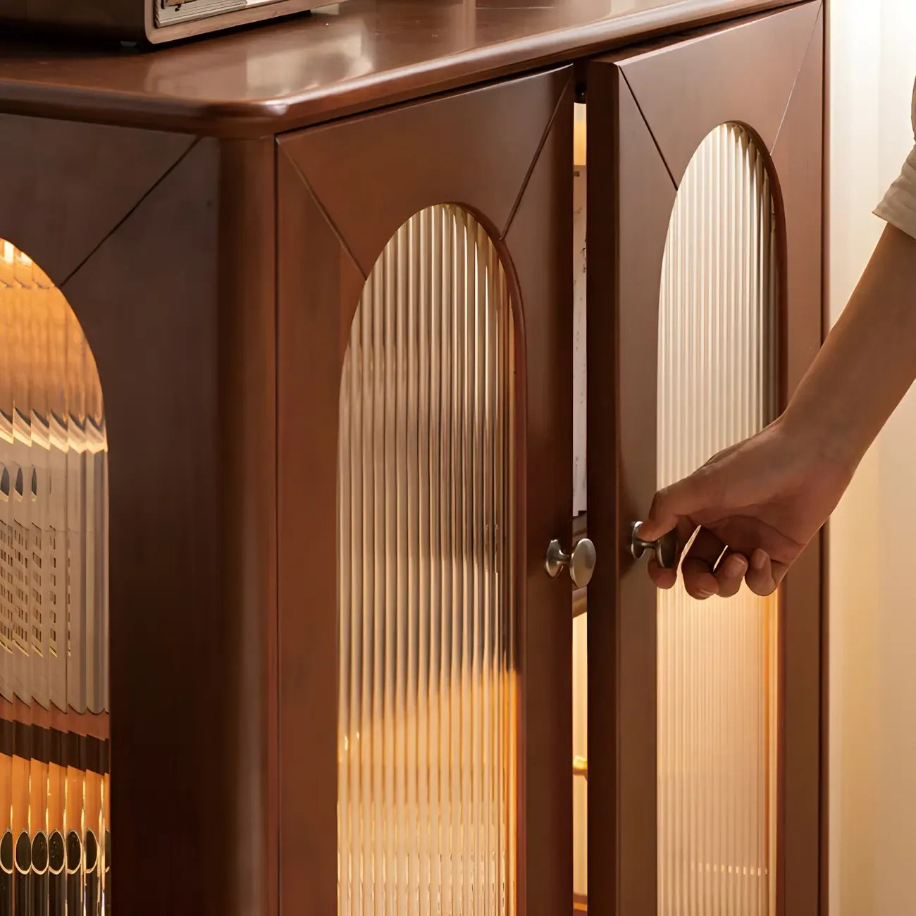Petit vaisselier en bois brun avec porte vitrée et éclairage intégré.