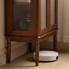 Petit vaisselier en bois brun avec porte vitrée et éclairage intégré.