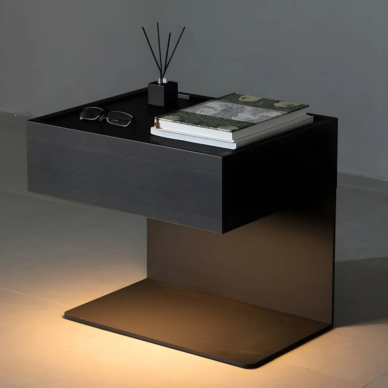 Table de chevet en forme de C avec tiroir et éclairage intégré, en acier noir et bois.