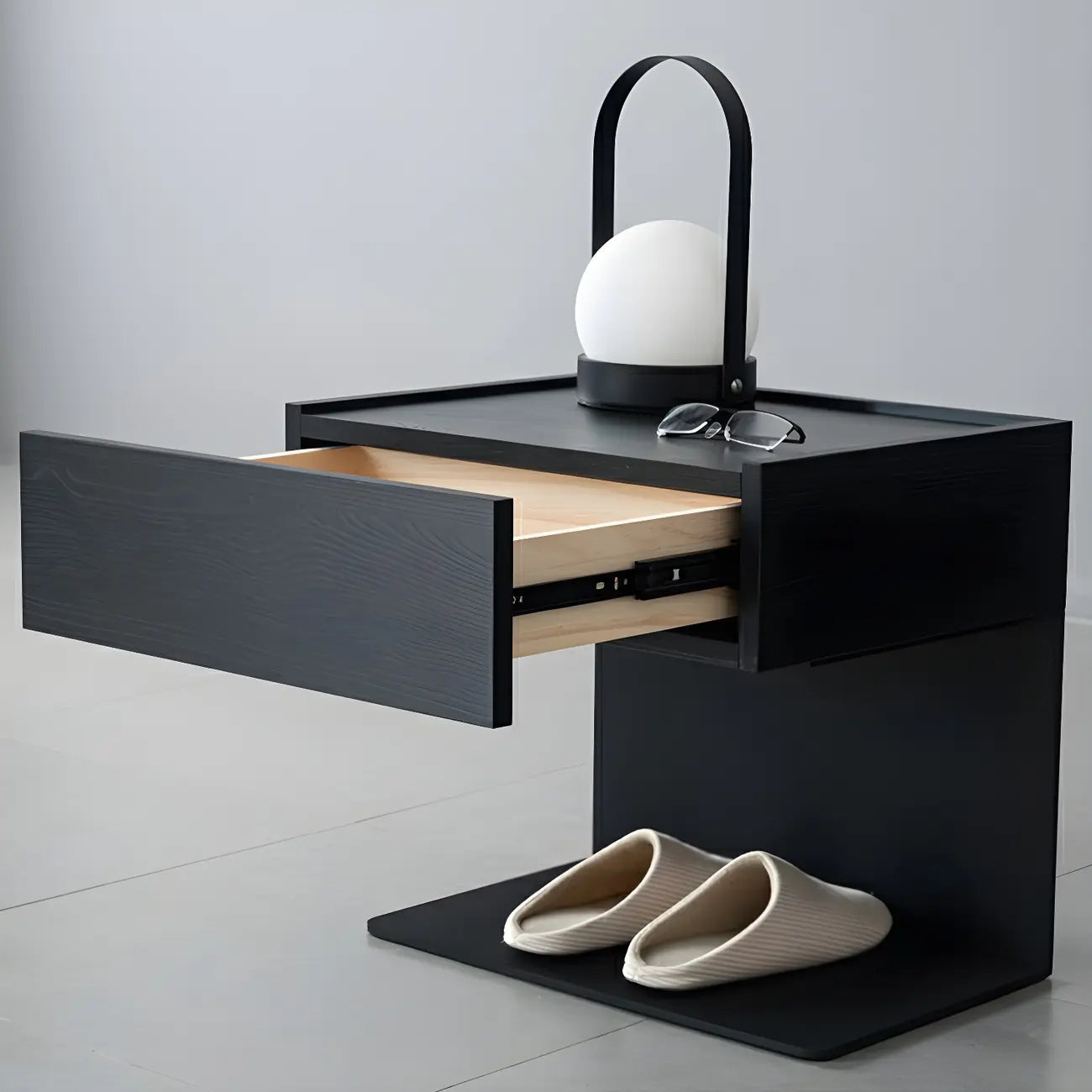 Table de chevet en forme de C avec tiroir et éclairage intégré, en acier noir et bois.