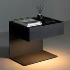 Table de chevet en forme de C avec tiroir et éclairage intégré, en acier noir et bois.